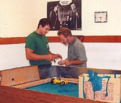 Cagle's Billiards employees repairing billiard table