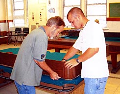 Cagle's Billiards employee repairing pool table felt