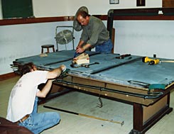 Cagle's Billiards employees installing billiard table lighting