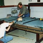 Cagle's Billiards employees installing billiard table lighting